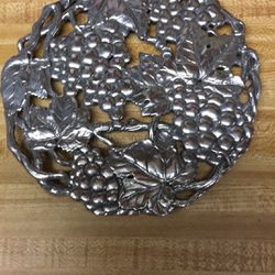 Arthur’s Court 1995 authentic.    8” aluminum grape clusters and grape leaves footed trivet  Taiwan original tag