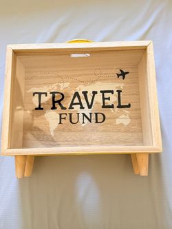 Wooden travel fund box with world map design.