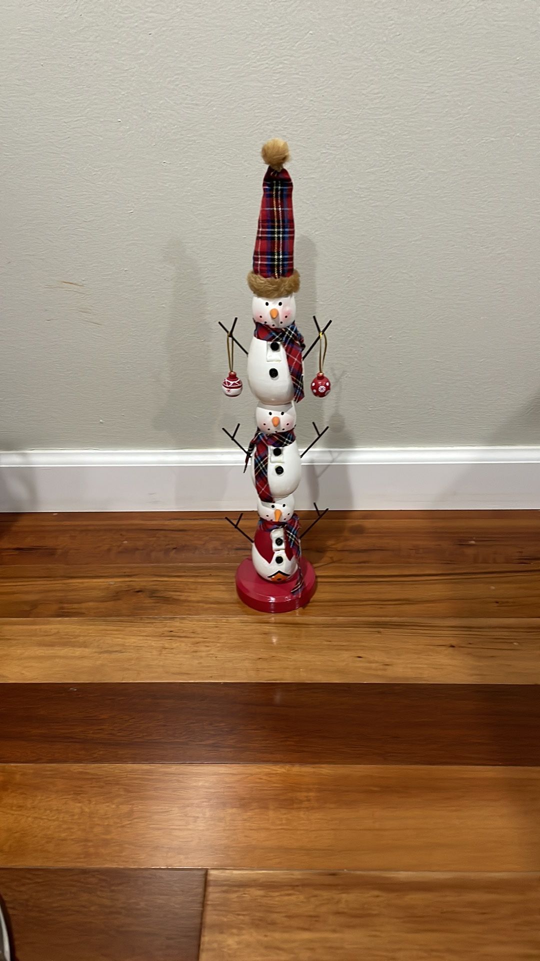 Charming snowman decor. Features plaid hat and scarf.