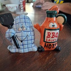 Pair of novelty BBQ sauce bottle and oven mitt figural salt and pepper shakers. 