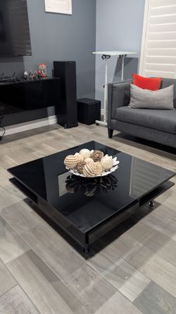 Glossy black coffee table with decor and storage