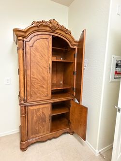 Ornate Wood Armoire with Carved Crown Detail