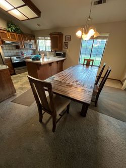 Large dining room table with bench on one side and and large glass top