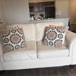 Beige sofa with patterned cushions 