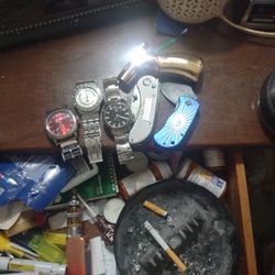 A Mixture Of Wrist Watches Small Pocket Knives And A Butane Lighter