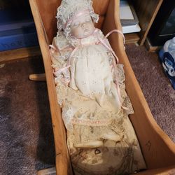 Porcelain doll.  Cradle included