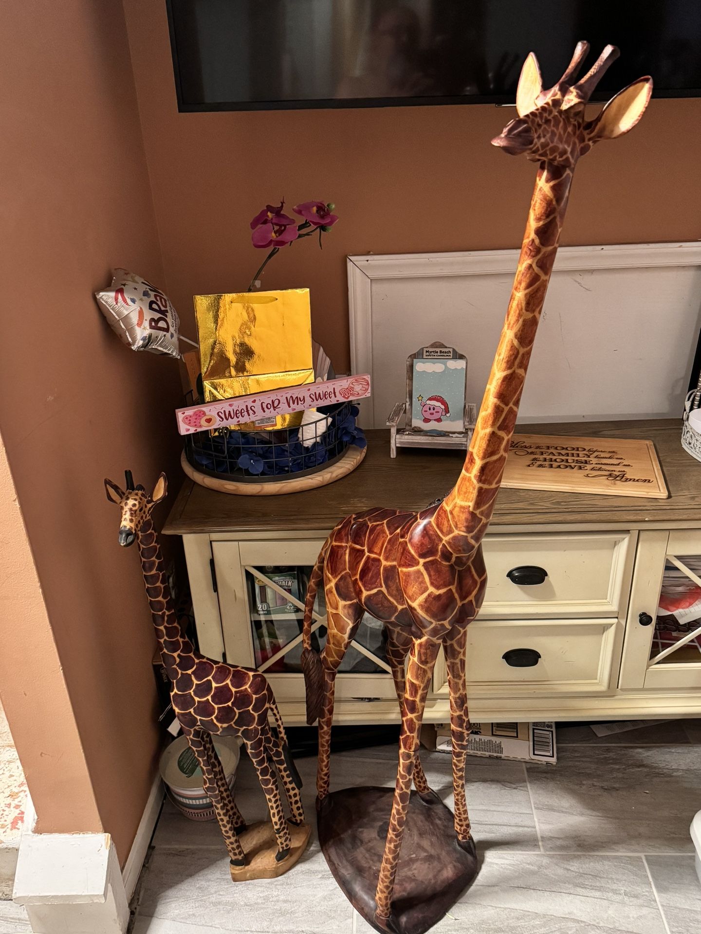 Mommy and baby giraffe carved in wood.