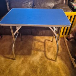 Medium Sized Metal folding Table. Very strong  20 by 32. Height 29. Hard rubber blue top. Folds easy. 
