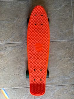 Bright orange penny board with green wheels