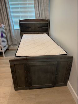 Twin bed frame with mattress and monkey board.