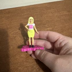 Chic small Barbie with a vibrant yellow skirt and pink base. Perfect for display or play.
