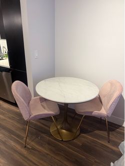 White marble table with 2 pink velvet chairs