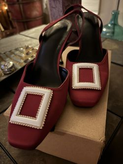 Red Satin Shoe With Rhinestones around the white and embellishment on the toe. Low acrylic heels.