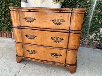 a vintage European style serpentine bombe commode with brass hardware.