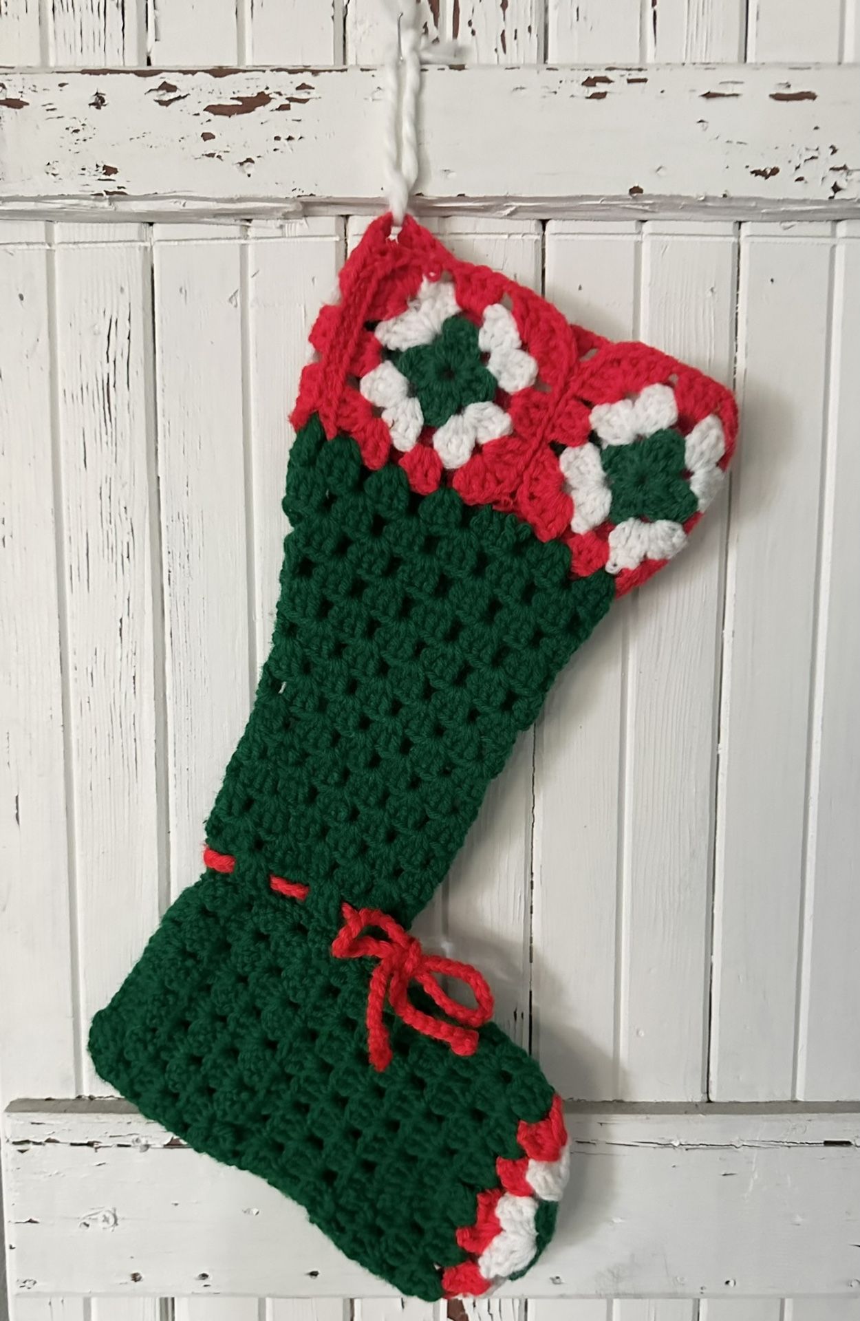 Vintage handmade crocheted green granny square Christmas stocking. Granny squares on the top and the toe. 15” long. Loop for hanging.