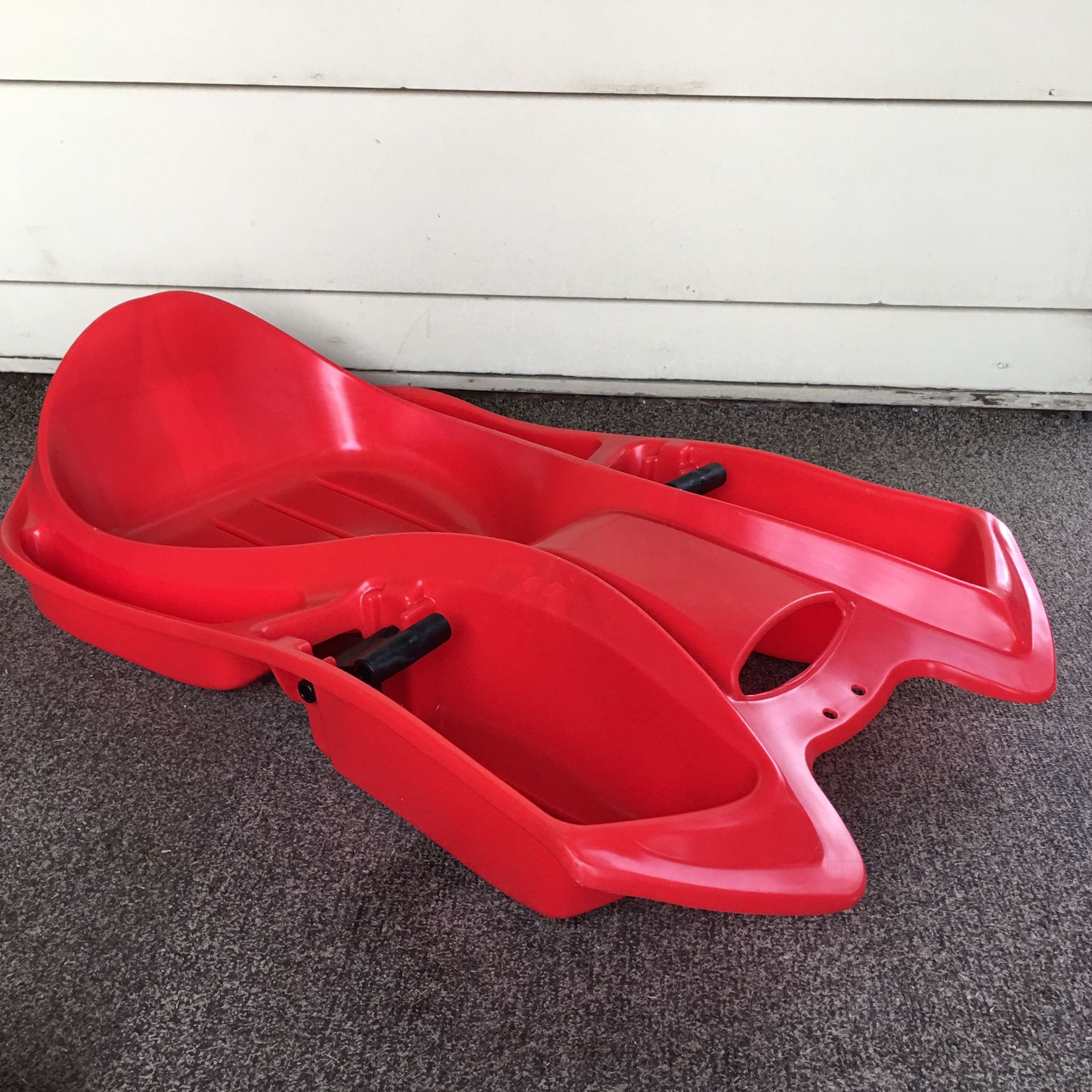 Youth red plastic sled by Paricon with molded back rest