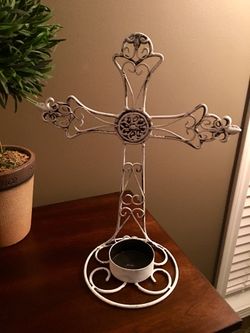 Rustic white metal scrolled cross.. holds a tealight candle. 14” tall.