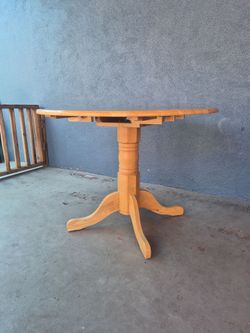 Sunset Trading round drop-leaf table, light oak finish