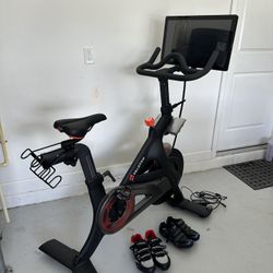 Peloton 1st Generation Bike And 2 Pair Of Shoes