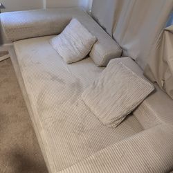 A NEW assemblable off-white sofa