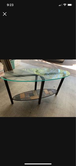 Thick oval glass top table with steel/stone multi colored at bottom