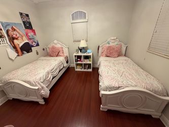 Set of white twin beds with mattress
