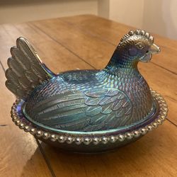 Iridescent blue carnival hen on nest