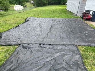Heavy-duty black vinyl (or polyethylene) tarp with reinforced webbing straps and D-rings/grommets.