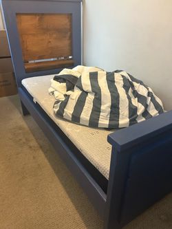 Twin XL bed with bedding and extra sheets