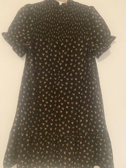black mini dress, smocked high neck, short puff sleeves, small heart pattern.