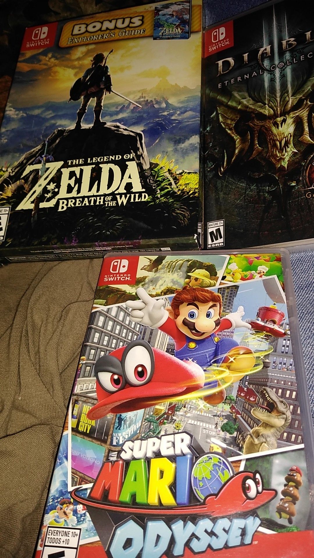 3 Nintendo switch games. Mario odyssey-Diablo eternal collection-The legend of Zelda breath of the wild bonus explorers guide