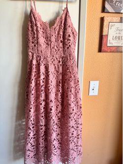 Romantic crochet lace midi with thin adjustable straps. Fitted bodice and defined waist. Flowy, feminine skirt with intricate floral cutwork. Soft dus