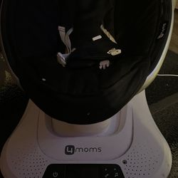 A swing for a baby, it works with electricity and has different modes and sounds.