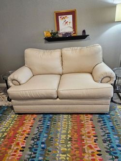 Thomasville brand white/natural loveseat with silver nail heads.