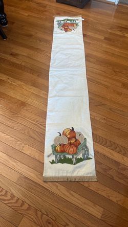 Pier 1 Imports autumn table runner featuring embroidered pumpkins in a green wagon with charming fringed ends