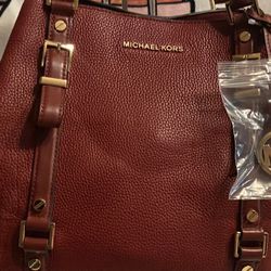 Authentic pre-love Michael Kors show the bag large in the color burgundy with gold hardware