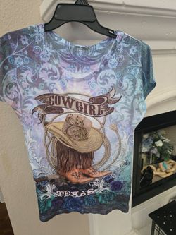 This Sweet Gisele rhinestone-embellished "Texas Cowgirl" top features a blue and purple floral graphic design.Brand: Sweet https://offerup.com/redirec