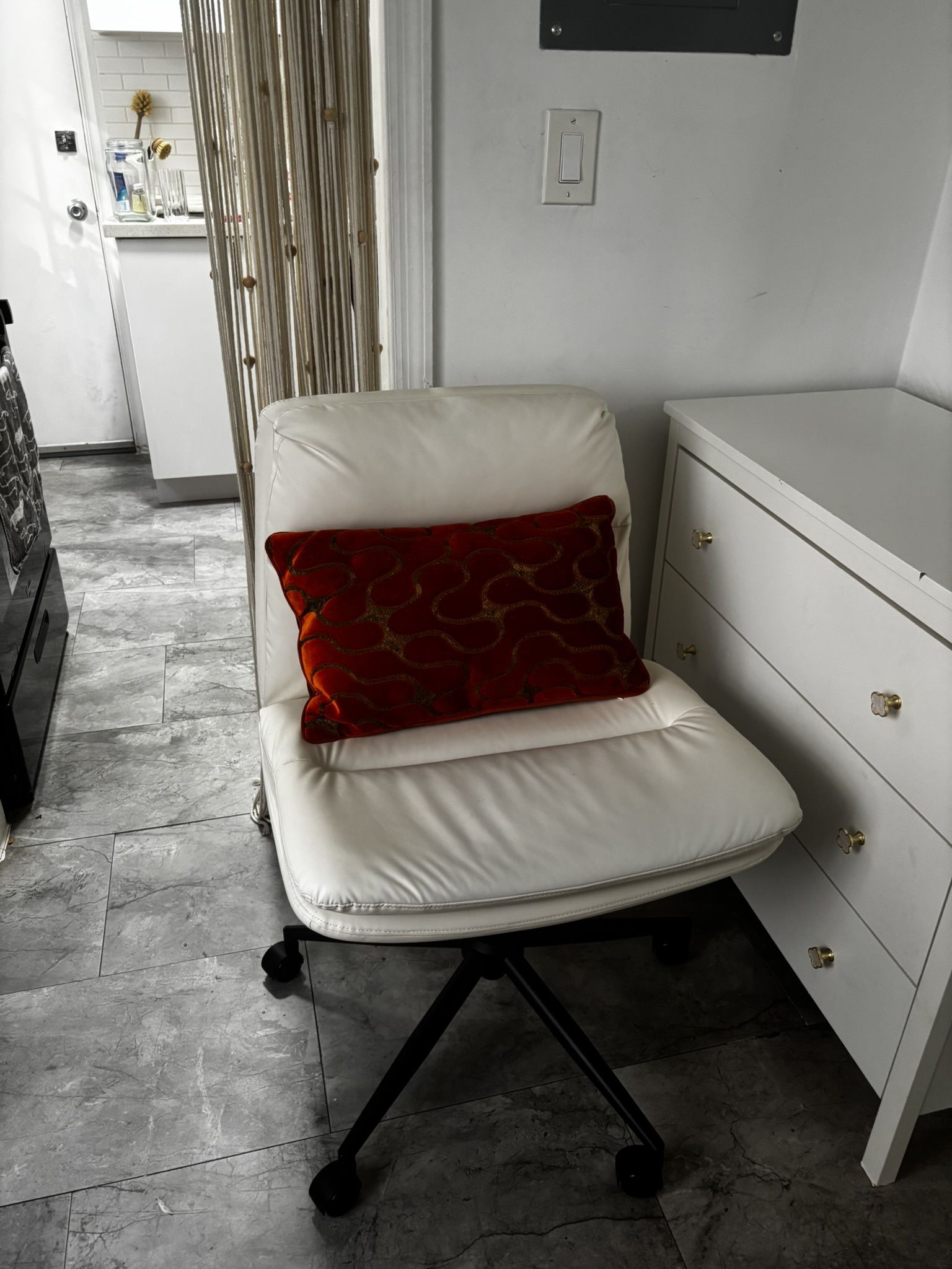 White rolling chair with pillow