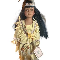 Induma is a collectible Native American Porcelain Doll. 16" in height standing.( comes with doll stand) Porcelain head,hands,and feet,wears a beautifu