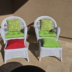 2 white swivel chairs and ottomans