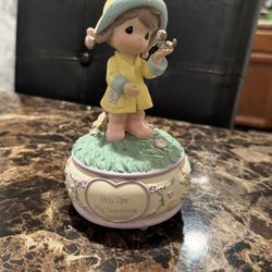Precious Moments "You Are My Sunshine" musical figurine, featuring a young girl in a yellow raincoat