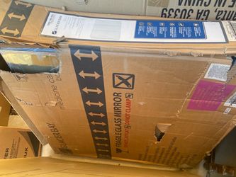 a severely damaged cardboard shipping box containing a Glacier Bay Bathroom Medicine Cabinet with Mirror