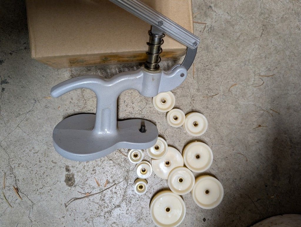 hand-operated press tool with various dies.