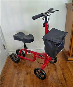 KNEE WALKER/SCOOTER: FOLDABLE.  ADJUSTABLE. FRONT POUCH. DUAL HAND BRAKES, BASKET.  RED FRAME. BRAKE LOCKING MECHANISM.  EXCELLENT CONDITION!