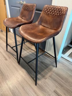 Two brown leather bar stools