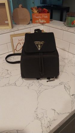 Vintage 90s Guess nylon mini backpack with classic silver triangular plaque logo drawstring closure and a front zippered  pocket