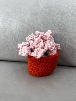 Handmade crocheted pink flower coaster with orange basket