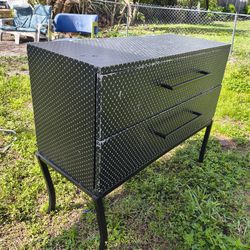 modern two-drawer chest of drawers or dresser featuring a black patterned finish and long metal handles, supported by slender metal legs
