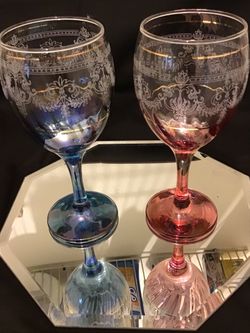 Two beautiful crystal wedding or anniversary wine glasses one pink one blue with white edging and gold ribbon