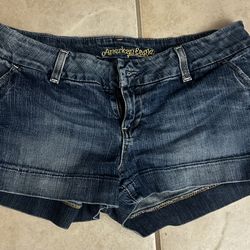 American Eagle Outfitters denim shorts featuring a dark wash, rolled cuffs, and a classic five-pocket design.